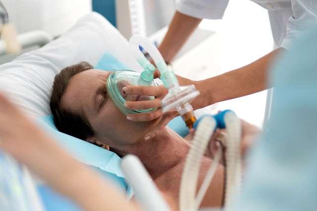 一名中年男子在医院使用呼吸设备进行机械通气